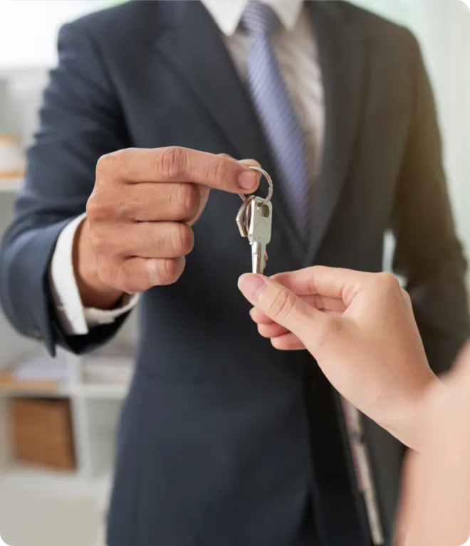 Man handing a woman keys to a house.