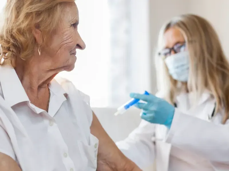 A nurse administering a vaccine to an elderly patient.