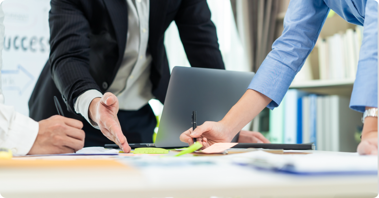 A corporate meeting in progress with a laptop computer on the table.