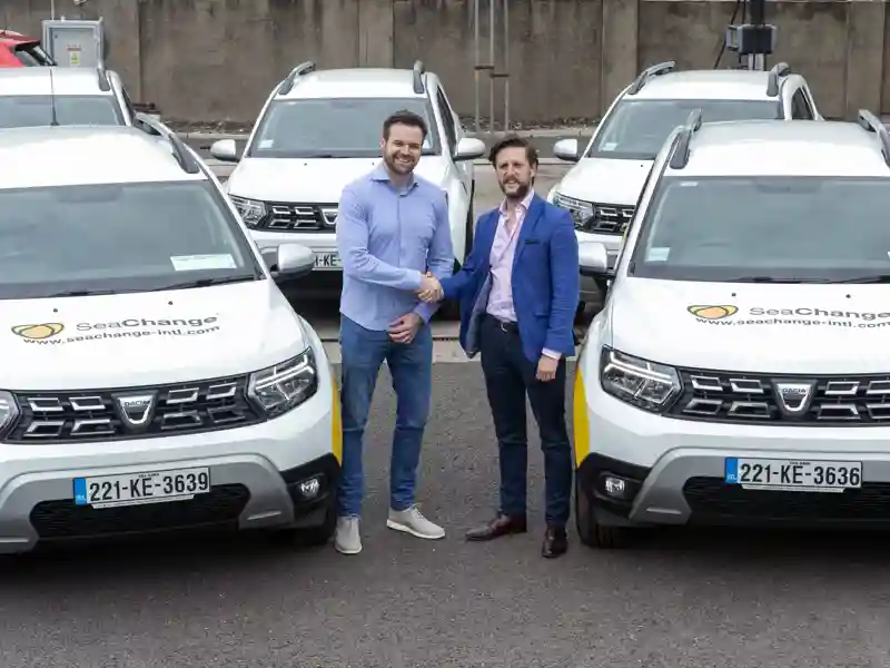 SeaChange employees posing in a car lot