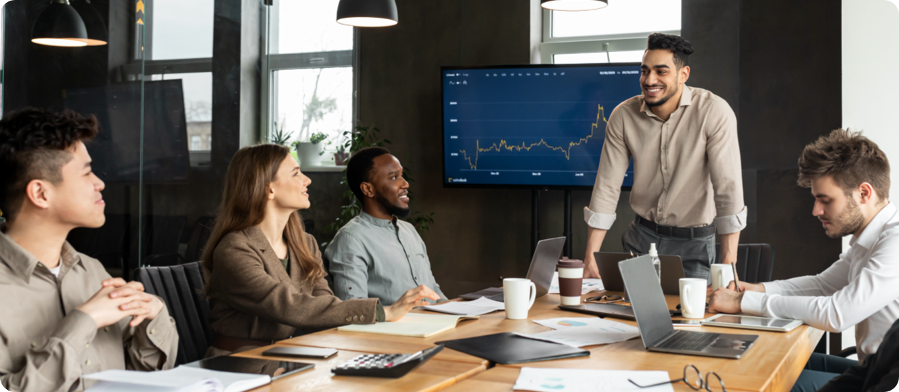 Agency meeting discussing a chart shown on a big screen TV.