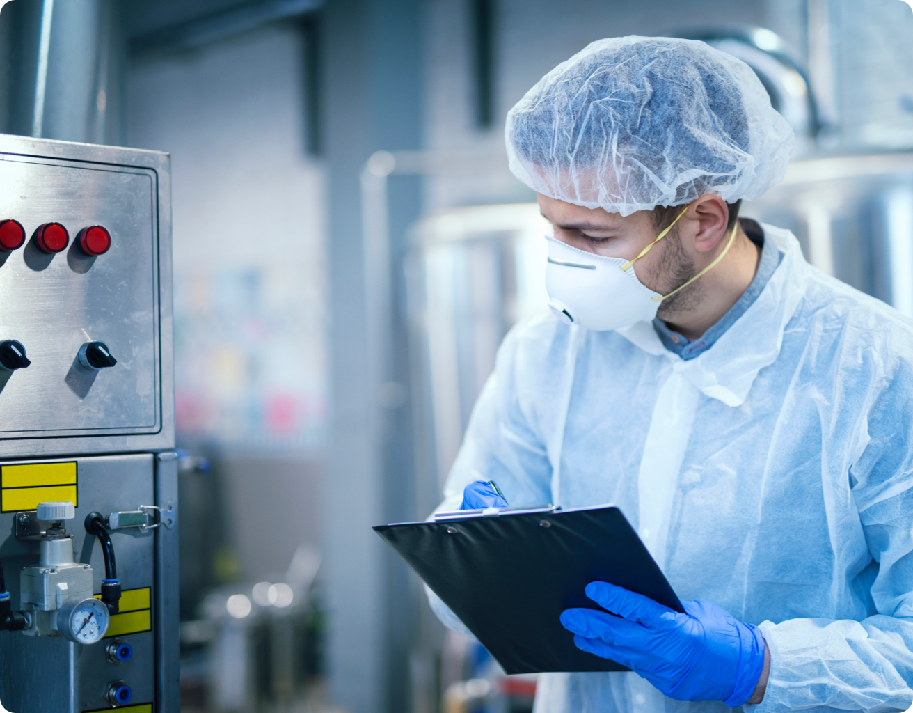 Factory safety officer, wearing a face mask, checking the valves.