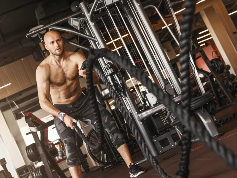Person working out using ropes at a gym.