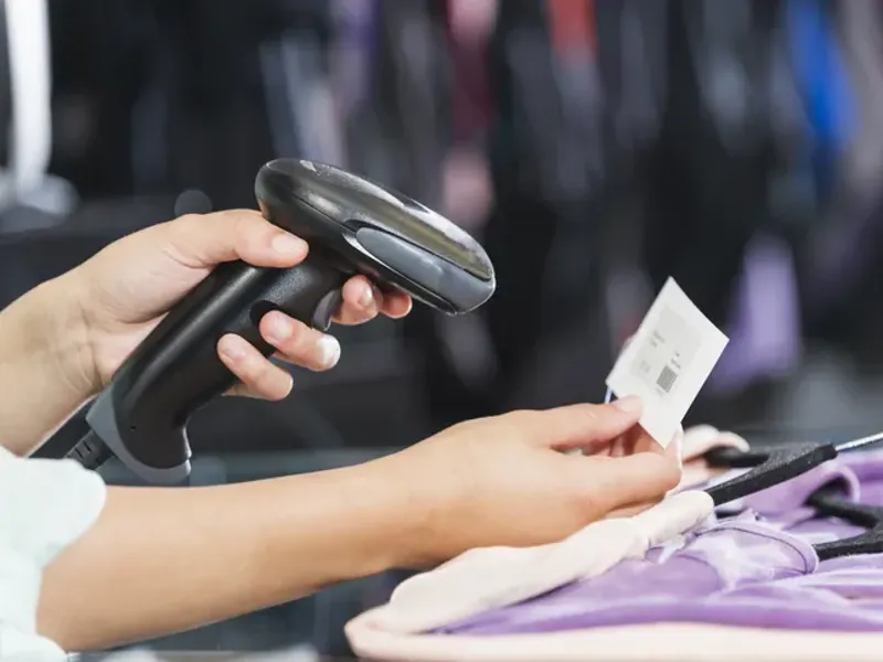 Store employee scanning clothing at check-out.