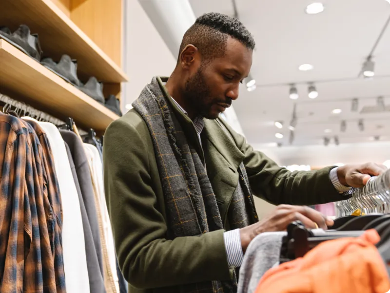 Young man shopping for clothing at a store.