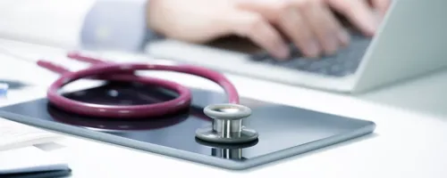 A stethoscope placed on top of a touchscreen tablet.