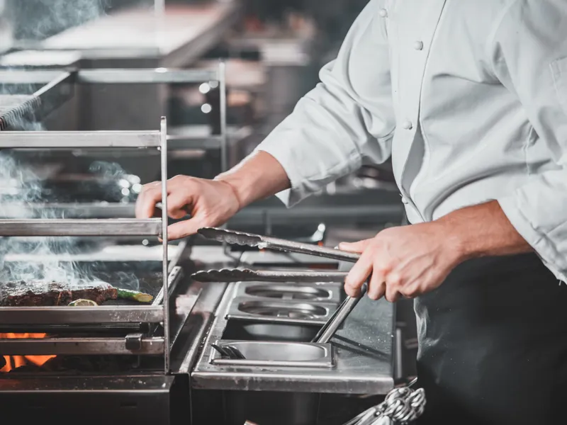 A chef grills food items
