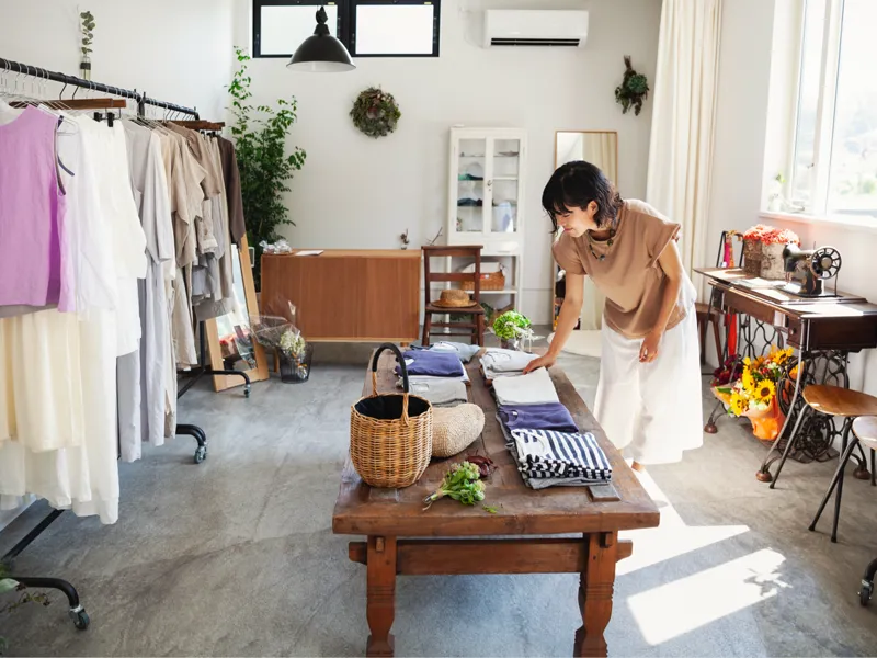 Clothing store shop keeper straightening up.