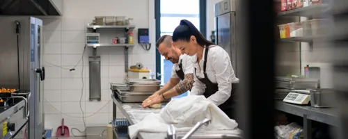 Two bakers work in a kitchen