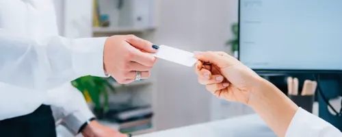 One person offers a card to another